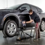 QuickJack 6000TL portable car lift shown in use for auto detailing providing easy access to wheels and lower panels.