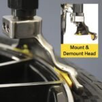Precision mount and demount head on the R745 tire changer shown engaging the wheel rim for controlled and damage-free tire service